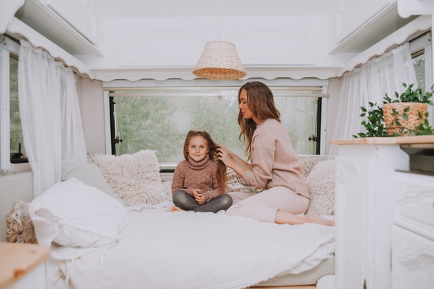 happy-family-mother-little-daughter-relaxing-countryside-inside-white-scandinavian-rustic-camper-van-interior_124463-2801